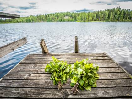 Laiturilla kaksi vihtaa, taustalla järvimaisema.