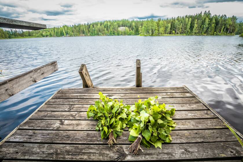 Laiturilla kaksi vihtaa, taustalla järvimaisema.