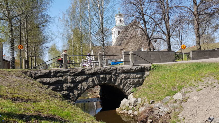 Kivisilta, jonka taustalla puita ja kirkko.