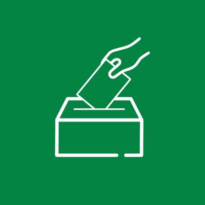 Valkoinen viivapiirros kädestä pudottamassa äänestyslipuketta laatikkoon vihreällä taustalla.