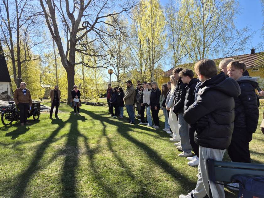 Ihmisiä aurinkoisella pihamaalla.