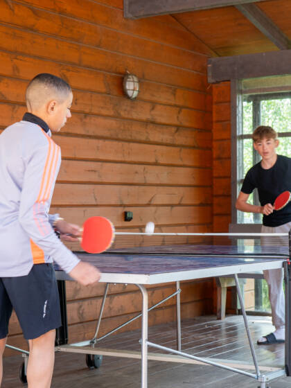 Kaksi nuorta pelaa pöytätennistä.