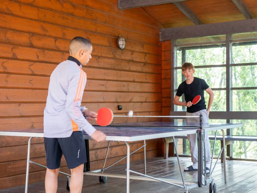 Kaksi nuorta pelaa pöytätennistä.