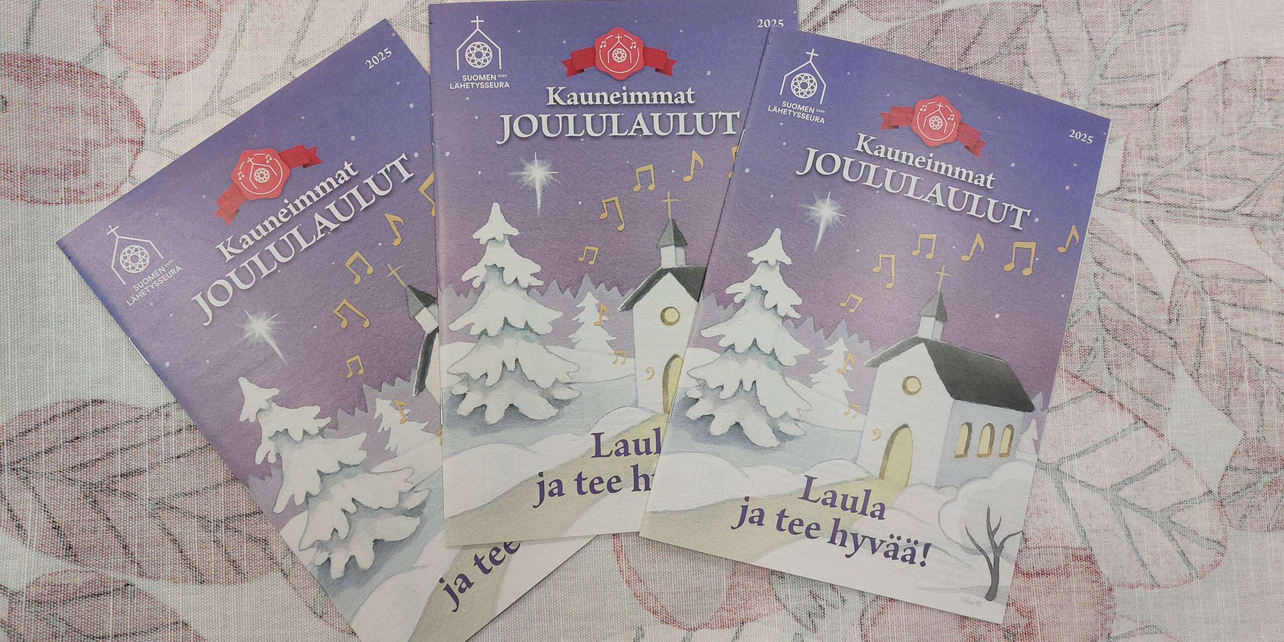 Kauneimmat joululaulut -lauluvihkoja pöydällä.