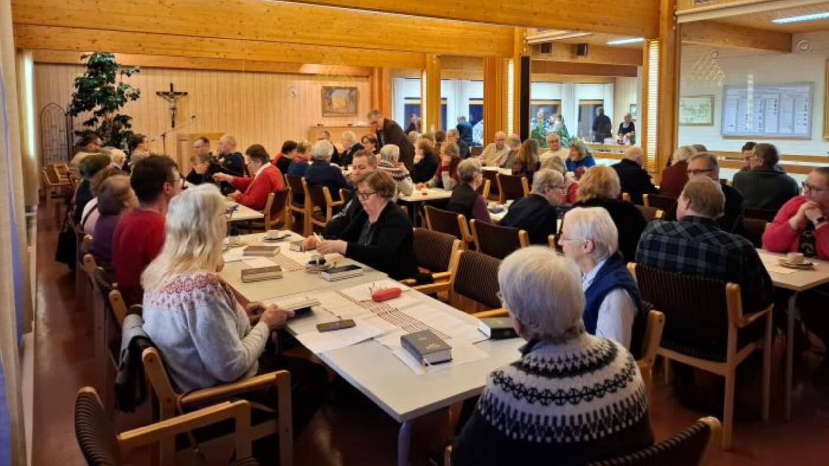 Ihmisiä pöytien ääressä.