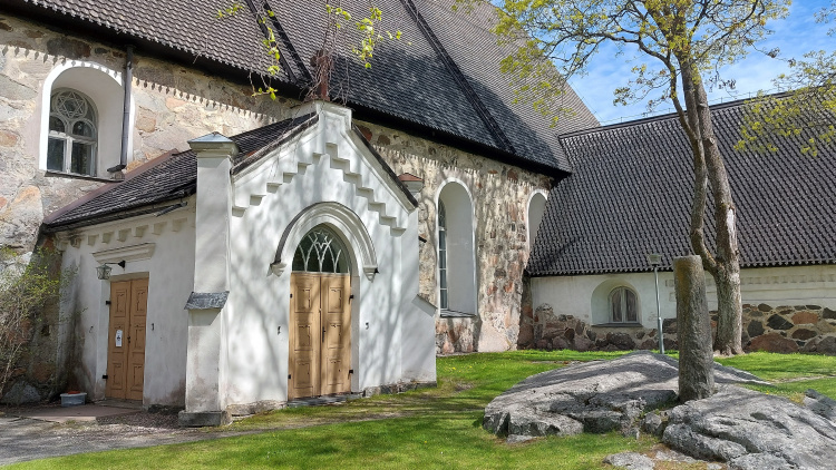 Kivikirkon seinää ja pihamaata.