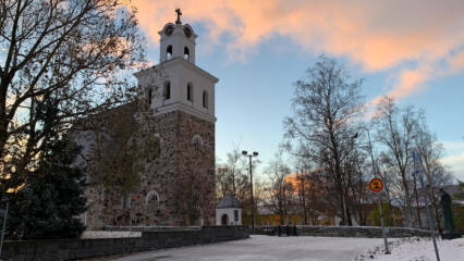 Auringonnousussa kivikirkko.